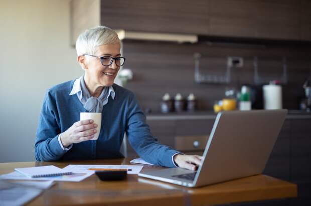 Person sitting at a table and using a laptop.