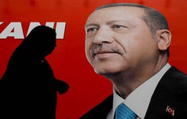 FILE PHOTO: A woman passes by an election poster of Turkey's President Tayyip Erdogan in Istanbul, Turkey June 23, 2018. REUTERS/Alkis Konstantinidis/File Photo