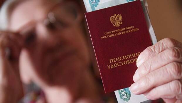 Женщина держит пенсионное удостоверение. Архивное фото Женщина держит пенсионное удостоверение. Архивное фото