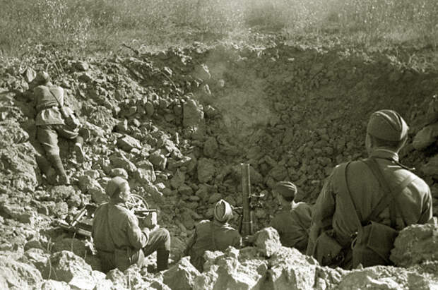 Солдаты ведут миномётный огонь из большой воронки от разорвавшегося снаряда. 1942 год