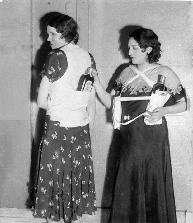 Эстелла Земон, слева, и женщина-модель показывают, как прятать бутылки с ромом и пройти мимо охранников во время сухого закона. 18 марта 1931 г. Фото: AP Photo.