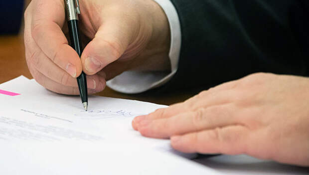 Президент Украины Петр Порошенко подписывает документ. Архивное фото
