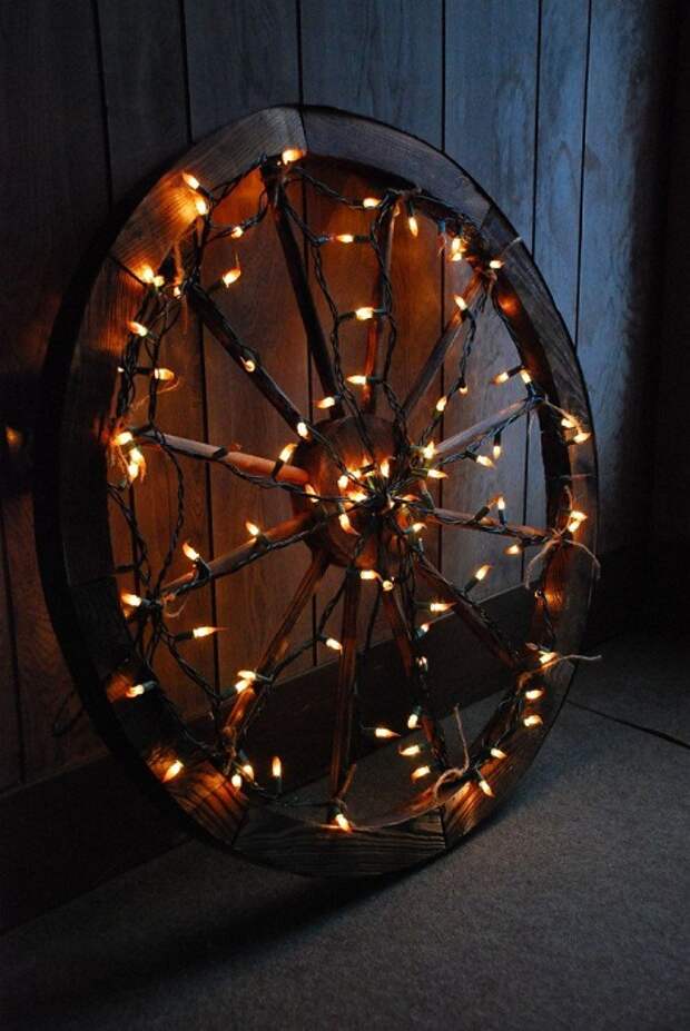 Нестандартное рождественское украшение - это колесо, которое украшено яркими огоньками.