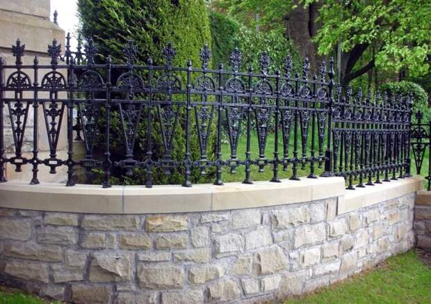 Кованый забор с каменным основанием подчеркнет стиль дома с прилегающим участком.