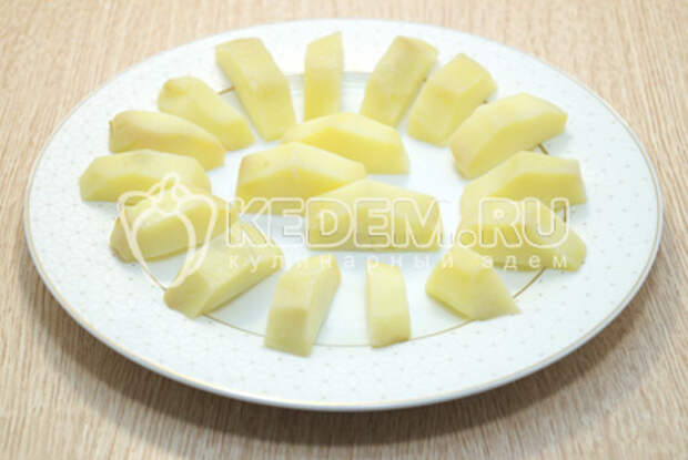 Каждую картофелину разрезать вдоль на половинки, затем разрезать на части. Выложить на блюдо и немного посолить.