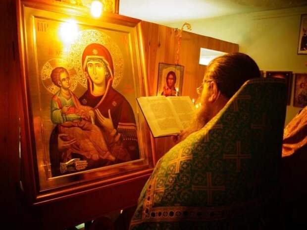 Священник молится у иконы в храме молитва иконе троеручица