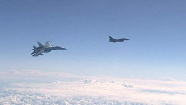 Истребитель НАТО F-16 и российский истребитель Су-27 над водами Балтики