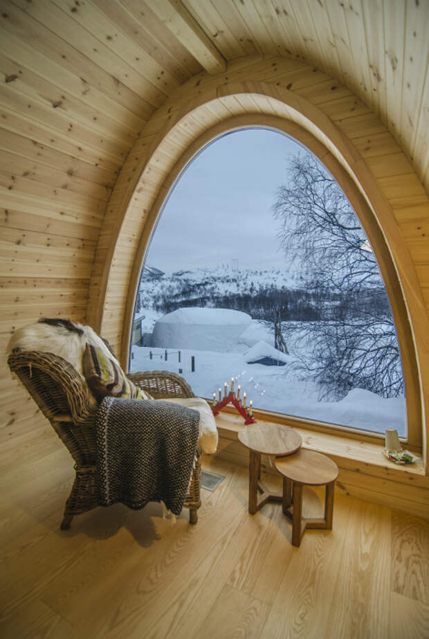 Большое полукруглое окно, которое позволяет беспрепятственно любоваться заснеженными пейзажами. Норвегия.