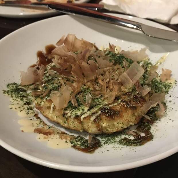 A seafood okonomiyaki topped with bonito flakes