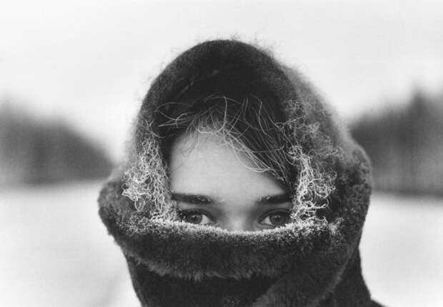 Симпатичная девушка закрывает лицо в лютый мороз. 