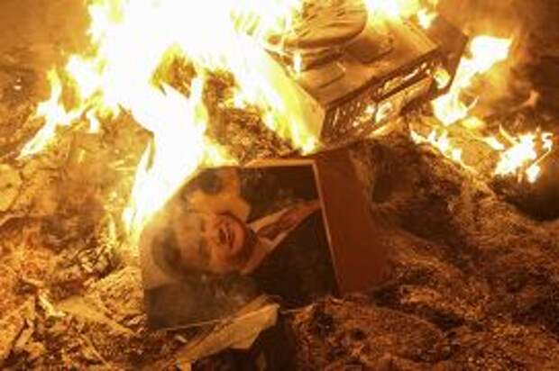 Портрет Виктора Януковича в огне рядом с разрушенным отделением милиции во Львове
