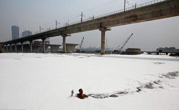Индийская река покрылась токсичной пеной, но местные продолжают купаться