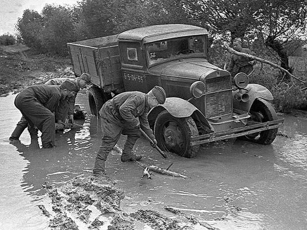 Советские солдаты вытаскивают из дорожной грязи застрявший грузовик-"полуторку" ГАЗ-АА (или ГАЗ-ММ).