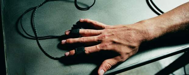 Person's hand hooked up to polygraph test, close-up (Overhead view)