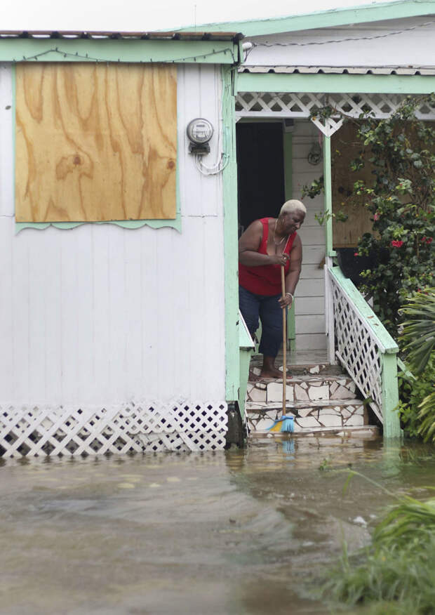 Жительница острова Антигуа выметает из дома воду после прохождения урагана Ирма Центральная Америка, ирма, катастрофа, разрушения, стихийное бедствие, стихия, ураган, флорида