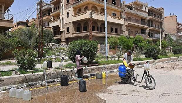 Жители набирают воду на улице в сирийском городе. Архивное фото