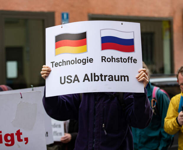 Протестующий против санкций немец держит плакат: "Германия - технологии, Россия - сырье, США - страшный сон". Фото: globallookpress.com/ IMAGO/ Alexander Pohl
