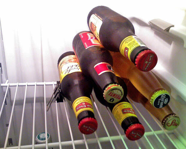 Используйте канцелярский зажим, чтобы зафиксировать бутылки в холодильнике горизонтально.