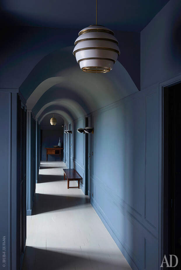 Один из коридоров в здании шале. Потолочные светильники по дизайну Алвара Аалто; бра по дизайну Макса Инграна, FontanaArte.