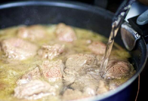 Обжаренное мясо заливают бульоном и тушат около часа / Фото: kulray.ru