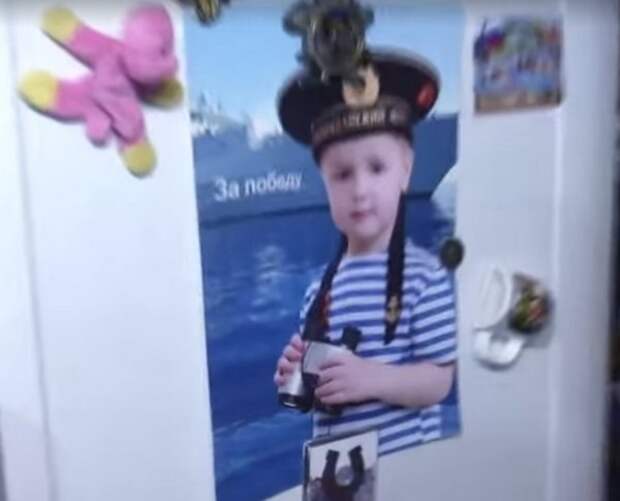 Фото внука хозяйки, прикрепленное на дверцу холодильника. Справа вверху российский флаг