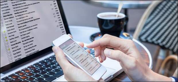 Business person reading email on smartphone and laptop