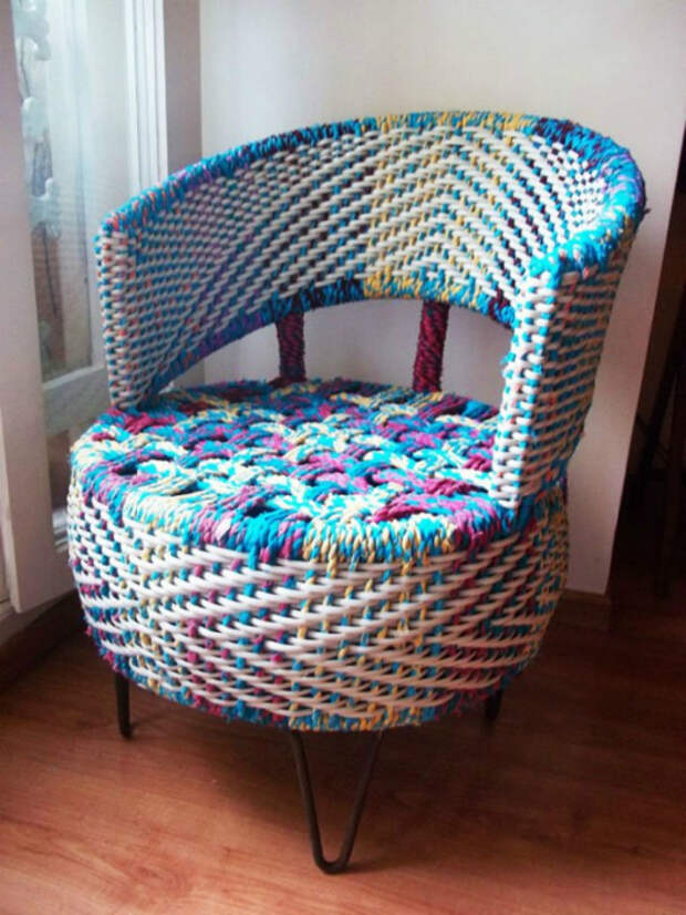 Оригинальное плетеное кресло из старой автомобильной шины, грубых разноцветных ниток и металлических прутьев.