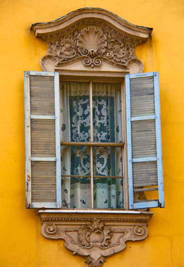 Окно в раме, стилизованной под золото, украшенное лепниной. Парма, Италия.
