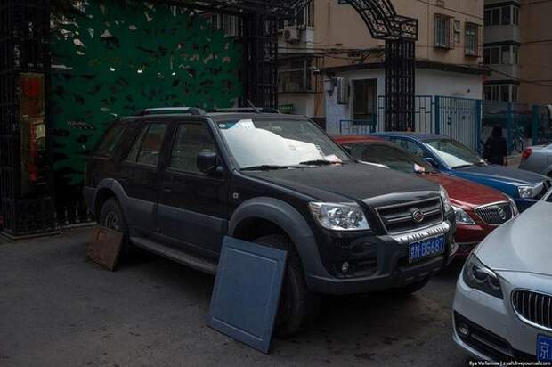 В Китае многие водители во время парковки прикрывают колеса на своей машине куском фанеры или старой дверцей от шкафа. Зачем они это делают?