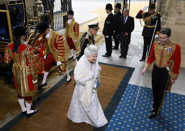 К прибытию королевы на башне Виктории Вестминстерского дворца вместо британского флага поднимается королевский штандарт. На фото: Елизавета II направляется в палату лордов в  Вестминстерском дворце, 2014 год