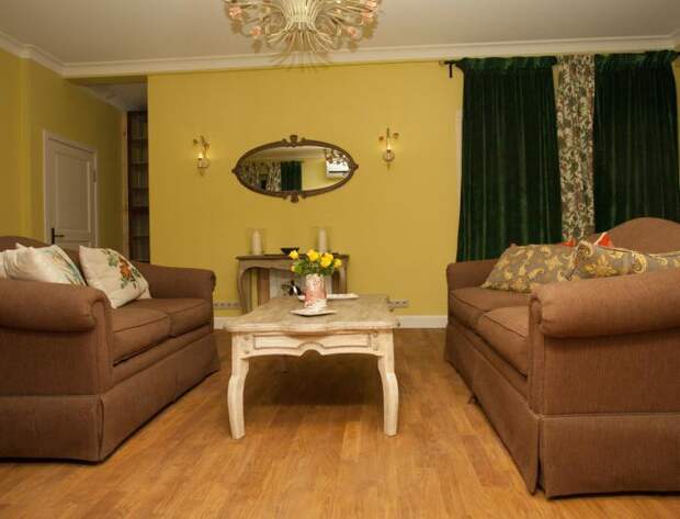 Интерьер гостиной в частном доме, журнальный столик между диванами, красивая люстра
