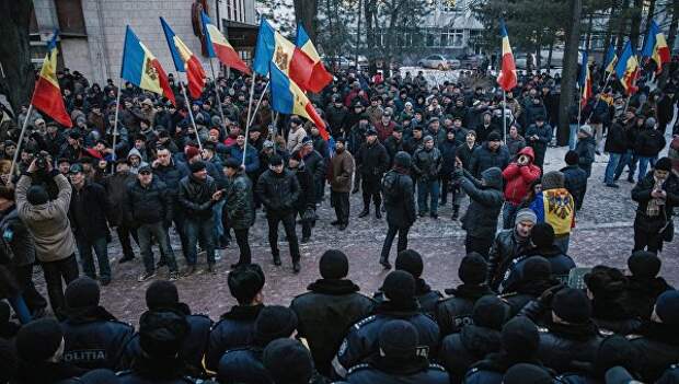 Протестующие и сотрудники правоохранительных органов у здания парламента в Кишиневе Протестующие и сотрудники правоохранительных органов у здания парламента в Кишиневе