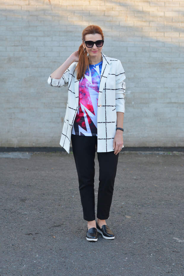 Mixed patterns: Windowpane check coat, graphic t-shirt, black trousers and slip on sneakers