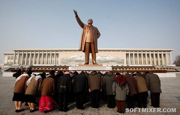 A group of people bow at the base of the giant bronze statue of the state founder and 'Great Leader' Kim-Il Sung in the North Korean capital of Pyongyang February 26, 2008.       REUTERS/David Gray      (NORTH KOREA) - RTR1XKVR