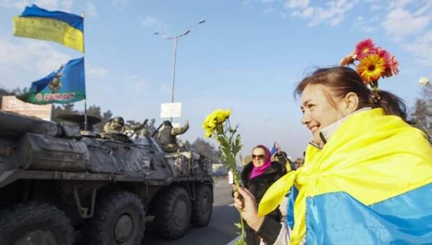 Ukrainians hold flowers as they greet servicemen in Kiev
