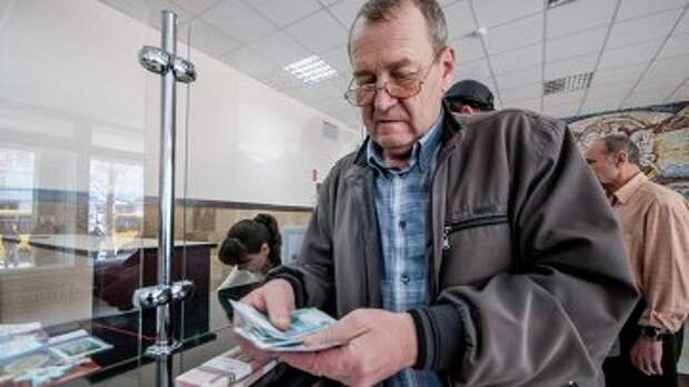 Мужчина получает пенсию в почтовом отделении. Архивное фото
