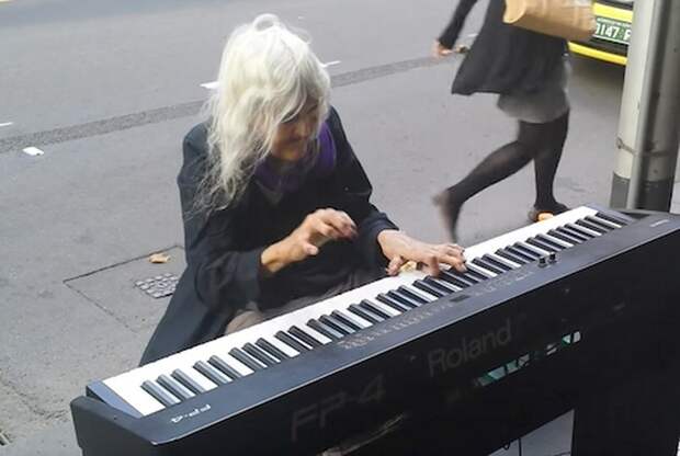 Бездомная старушка играет на пианино.