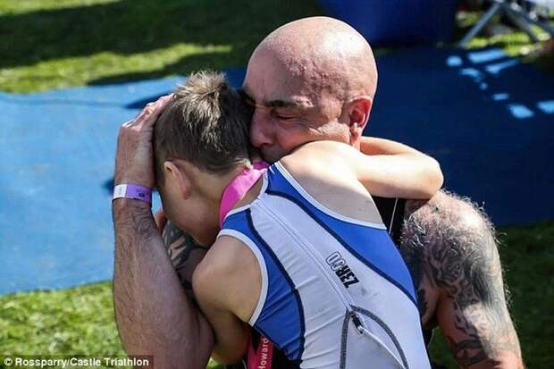Гордый отец Джонатан Метьюз обнимает своего сына Бэйли, который несмотря на тяжелое заболевание, не только смог финишировать в турнире по триатлону, но и завершил крайние 20 метров без специальных ходунков болезнь, жизнь, ребенок, финиш