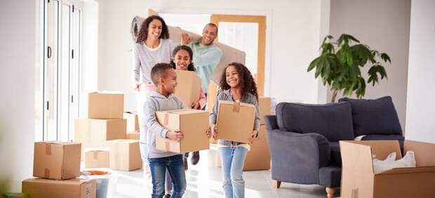 A family bringing moving boxes into a house