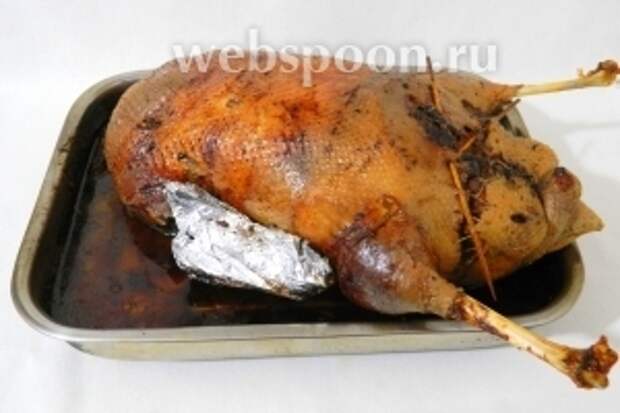 Затем, огонь снижаем до 160-150°С, гуся переворачиваем на спину, накрываем фольгой и запекаем в течении 2,5 часов, поливая выделившимся жиром. В конце снимаем фольгу и запекаем ещё 30 минут. Готовность проверяем прокалывая ножку шпажкой, должен выделиться прозрачный сок. Убираем шпажки, нитки, даём мясу немножко отдохнуть и подаём!