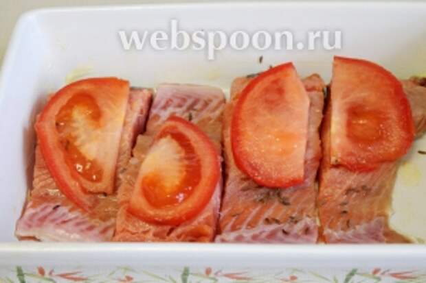 На каждый кусок рыбы уложить дольку помидора.