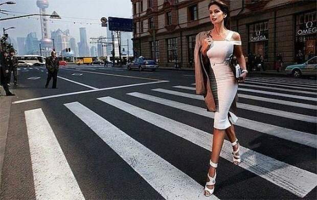 Хорошо одетая молодая женщина идет по улице. Улыбнемся))
