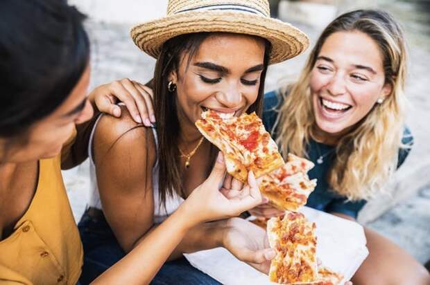 Group of friends enjoying pizza together.