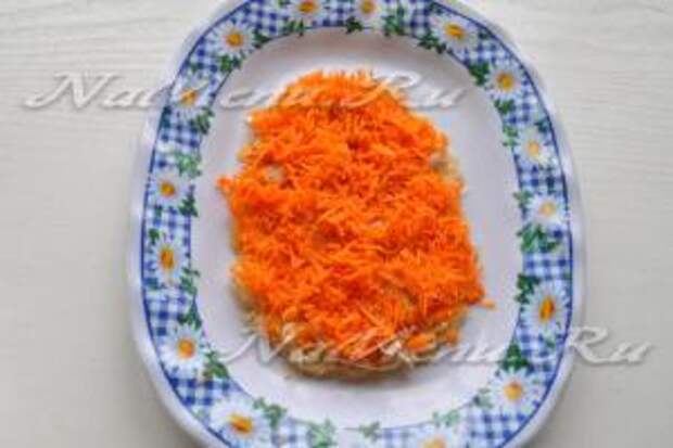 Морковь натрем на мелкой терке. Выложим ее сверху на мясо