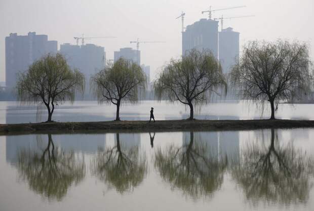 Женщина на фоне строящегося жилого комплекса в городе Ухань загрезнение, китай, природа