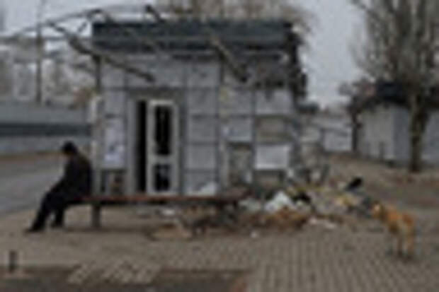 Житель Донецка возле разрушенной в результате артобстрела автобусной остановки