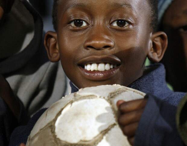 Ребенок с футбольным мячом на стадионе, фото