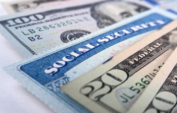 A Social Security card fanned out with U.S. currency.