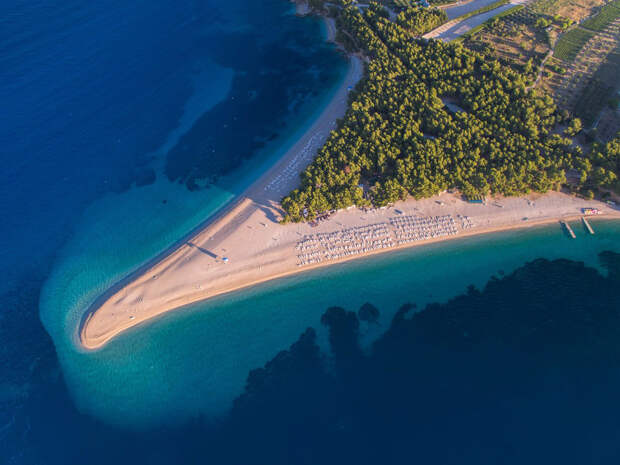 Zlatni Rat Брач, Хорватия Длинный язык песчаного пляжа на хорватском островке Брач выходит далеко в море. Белая галька покрывает практически всю территорию острова, а несколько средиземноморских сосновых рощ обеспечивают отдыхающим достаточное количество тени.