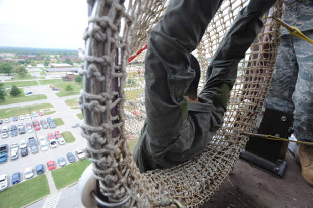Airman hang from side of tower down the fire escape tunnel preparing to release and descend, 133 feet down, 22 Sept. Anyone who works in the tower needs to go through this training to ensure they know what to expect in the descent of the extreme drop. (U.S. Air Force Photo by Airman First Carlin Leslie)